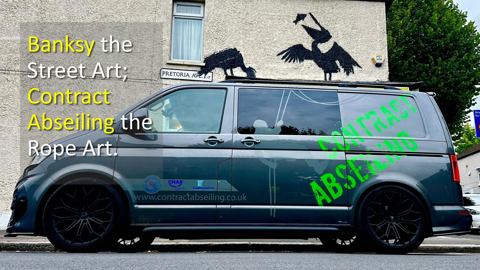 The image features a piece of street art by Banksy on a building wall, with a Contract Abseiling black van park in front.